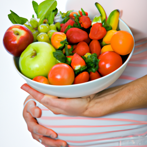 אישה בהריון מחזיקה קערה של פירות וירקות טריים